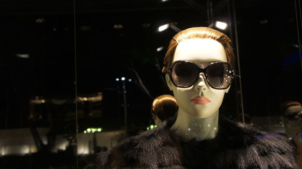 Female mannequin with black fur and sunglasses.
